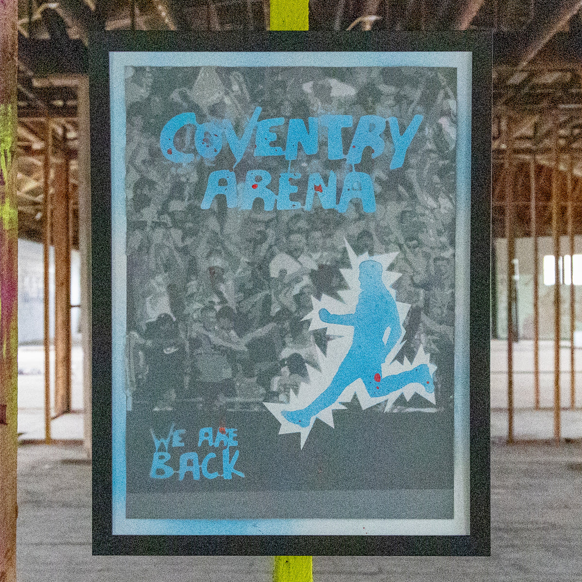 Coventry Arena hand-sprayed stencil art in sky blue with red drip accents over a grey crowd, framed in black, one-of-one Layered Original by Made By Cito