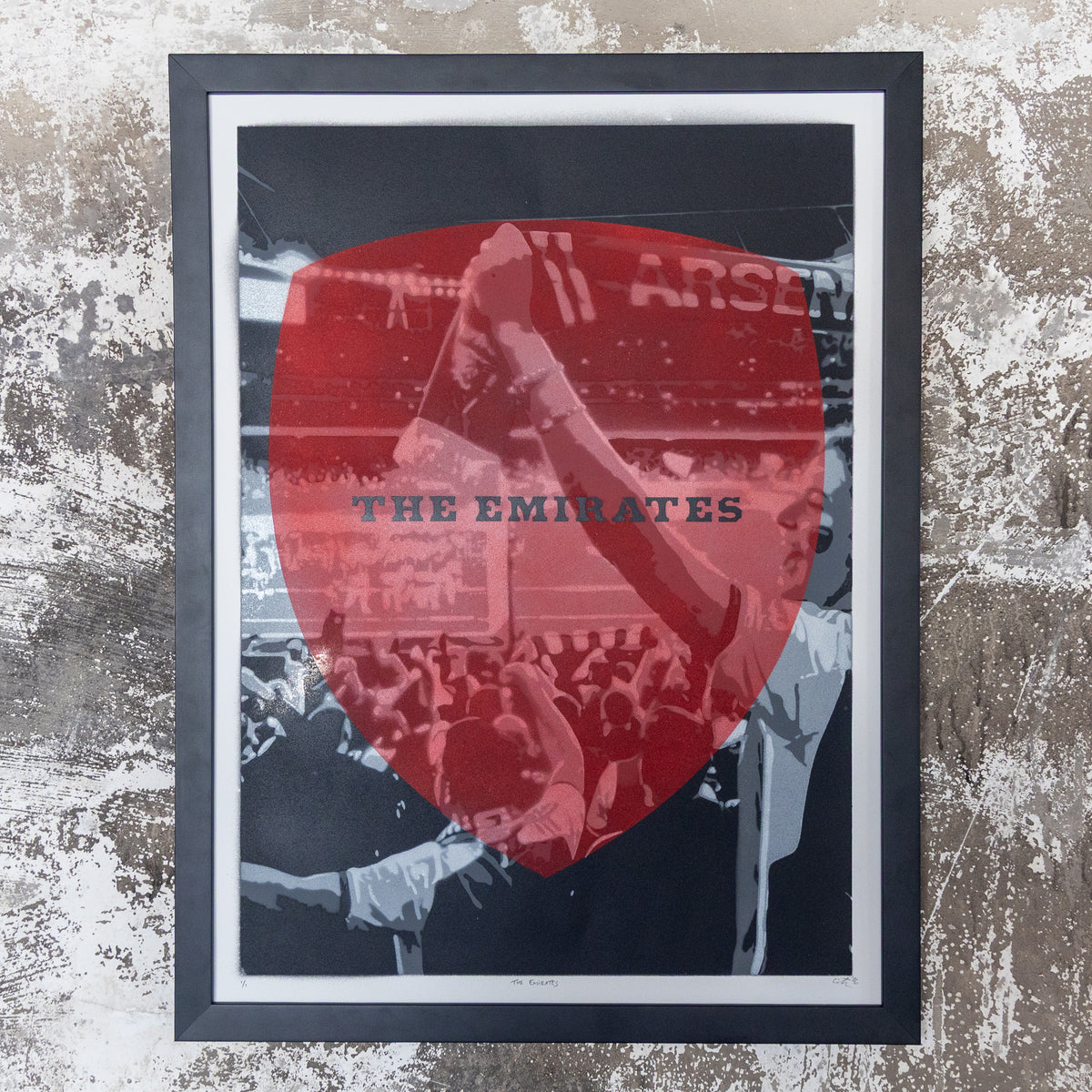 The Emirates Arsenal stadium hand-sprayed stencil art, red shield over a black-and-white crowd, framed in black, one-of-one Layered Original by Made By Cito